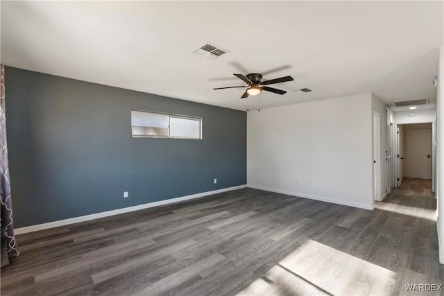 spare room with ceiling fan, dark wood-style flooring, visible vents, and baseboards