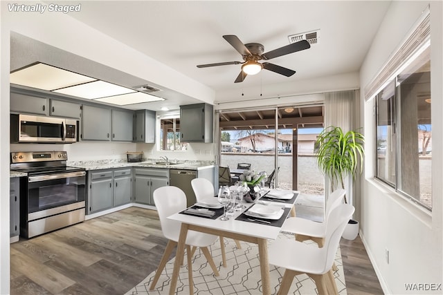 kitchen with appliances with stainless steel finishes, light countertops, visible vents, and gray cabinetry