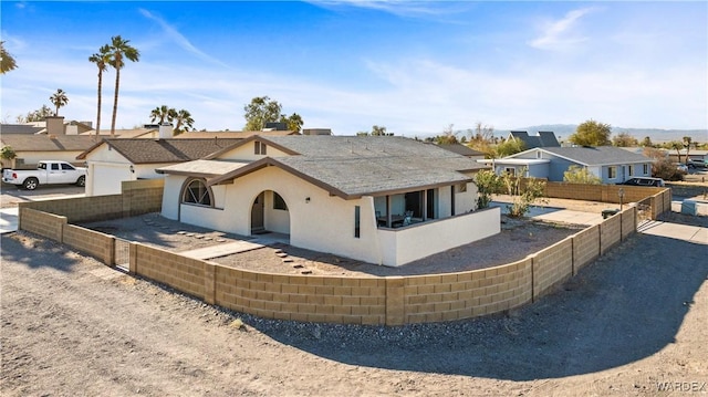 view of front of property with fence private yard, a residential view, and stucco siding