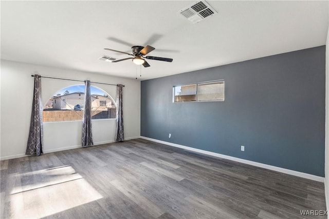 unfurnished room featuring visible vents, ceiling fan, baseboards, and wood finished floors