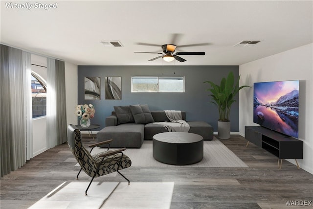 living area with visible vents, plenty of natural light, and wood finished floors