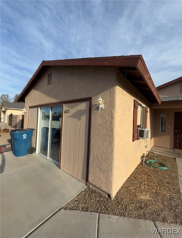 view of property exterior with cooling unit, a patio, and stucco siding