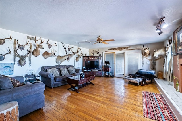 4390 El Camino Rd, Bullhead City, AZ 86429 - living area with hardwood / wood-style flooring, a textured ceiling, and a ceiling fan