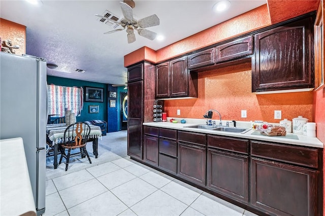 4390 El Camino Rd, Bullhead City, AZ 86429 - kitchen featuring freestanding refrigerator, light countertops, ceiling fan, light colored carpet, and dark brown cabinetry