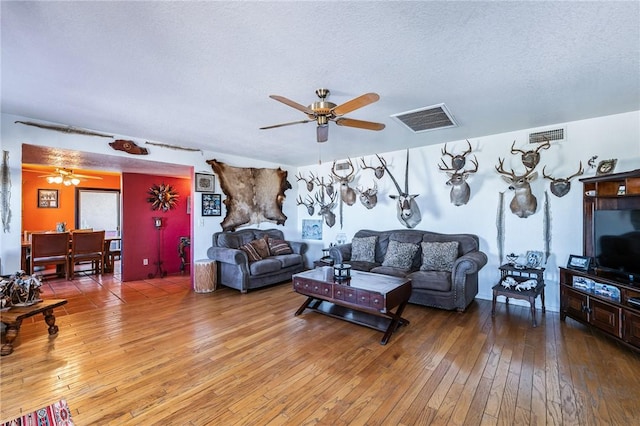 4390 El Camino Rd, Bullhead City, AZ 86429 - living area with a ceiling fan, light wood-style floors, and a textured ceiling