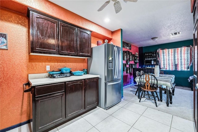 4390 El Camino Rd, Bullhead City, AZ 86429 - kitchen featuring stainless steel refrigerator with ice dispenser, light countertops, ceiling fan, a textured wall, and dark brown cabinets