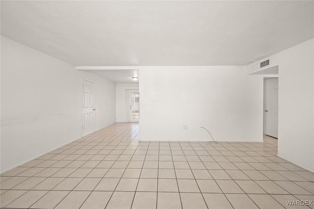 empty room with light tile patterned floors and visible vents