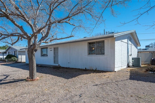 ranch-style house featuring concrete block siding and central AC