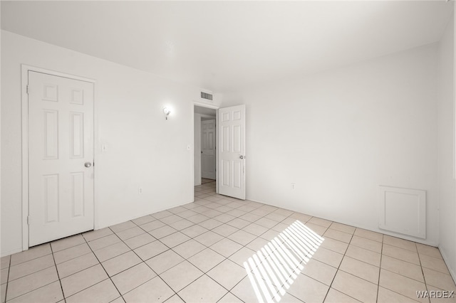 spare room featuring light tile patterned floors and visible vents