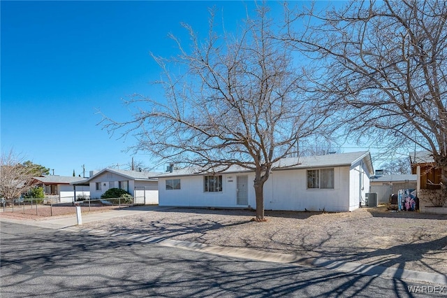 single story home featuring concrete driveway, fence, and central air condition unit