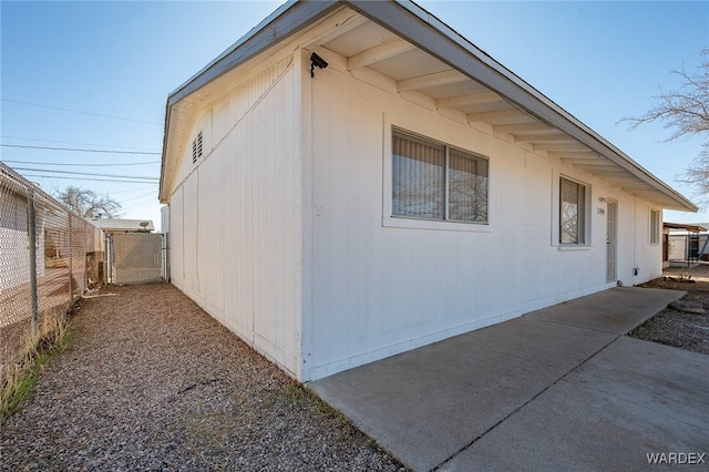 view of property exterior with a patio area and fence