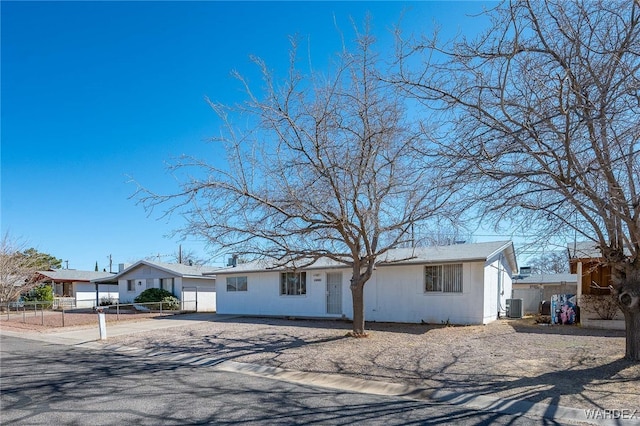 single story home featuring concrete driveway, fence, and central air condition unit