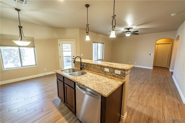 kitchen featuring decorative light fixtures, a sink, an island with sink, and stainless steel dishwasher