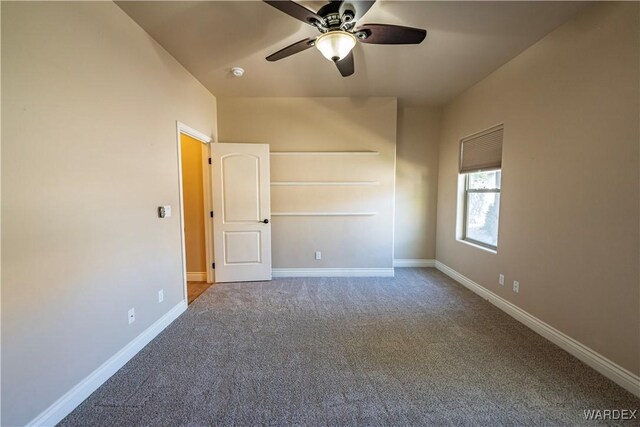 spare room featuring carpet, ceiling fan, and baseboards