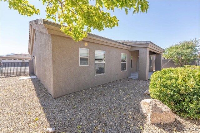 view of side of property with fence and stucco siding