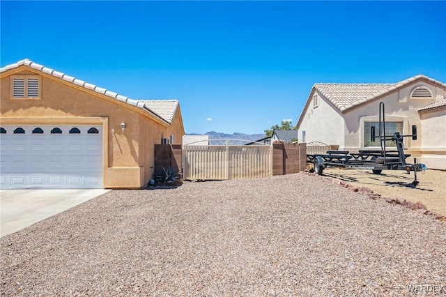 4403 S Via Rialto Ln, Fort Mohave, AZ 86426 - view of property exterior with fence, a garage, stucco siding, concrete driveway, and a tiled roof
