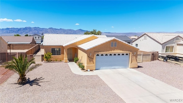 4403 S Via Rialto Ln, Fort Mohave, AZ 86426 - ranch-style house featuring a garage, fence, a mountain view, concrete driveway, and stucco siding