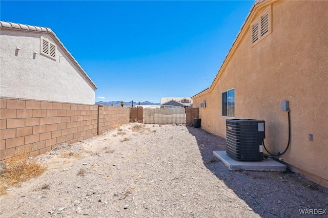 4403 S Via Rialto Ln, Fort Mohave, AZ 86426 - view of yard featuring central AC unit, a mountain view, and a fenced backyard