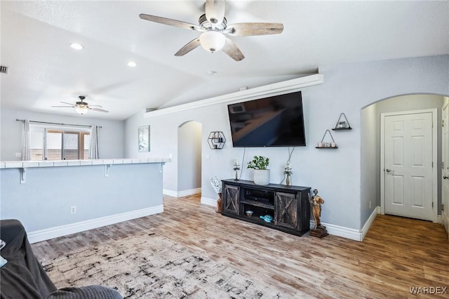 4403 S Via Rialto Ln, Fort Mohave, AZ 86426 - living room featuring ceiling fan, arched walkways, baseboards, light wood-type flooring, and vaulted ceiling