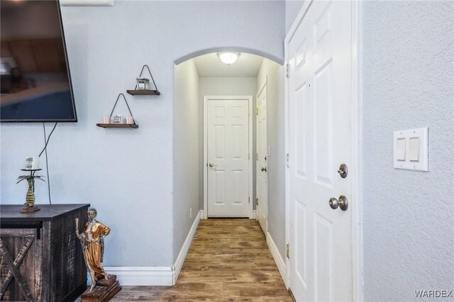 4403 S Via Rialto Ln, Fort Mohave, AZ 86426 - hallway with arched walkways, baseboards, and wood finished floors