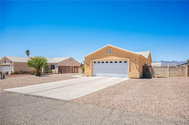 4403 S Via Rialto Ln, Fort Mohave, AZ 86426 - ranch-style house featuring fence, stucco siding, concrete driveway, an attached garage, and a tile roof