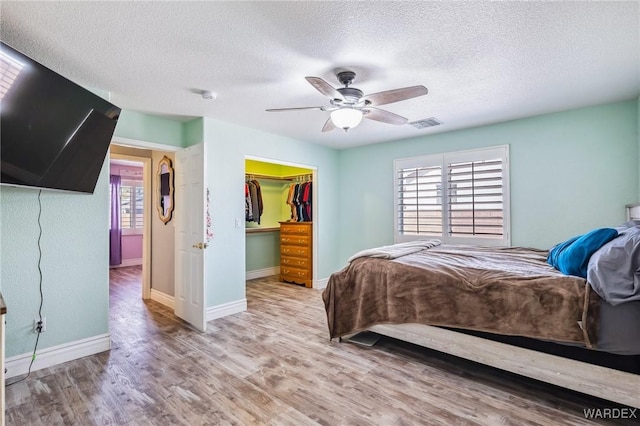 4403 S Via Rialto Ln, Fort Mohave, AZ 86426 - bedroom featuring visible vents, wood finished floors, baseboards, a walk in closet, and a textured ceiling