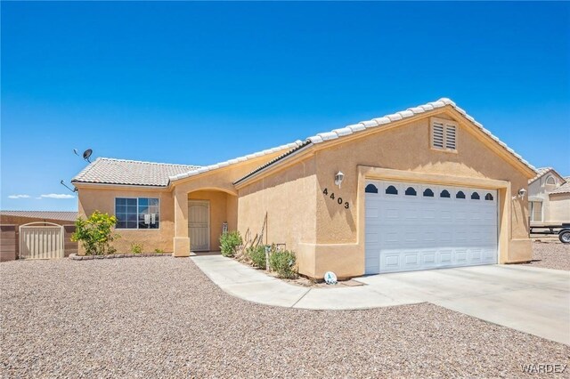 4403 S Via Rialto Ln, Fort Mohave, AZ 86426 - ranch-style home featuring an attached garage, stucco siding, a tile roof, and concrete driveway
