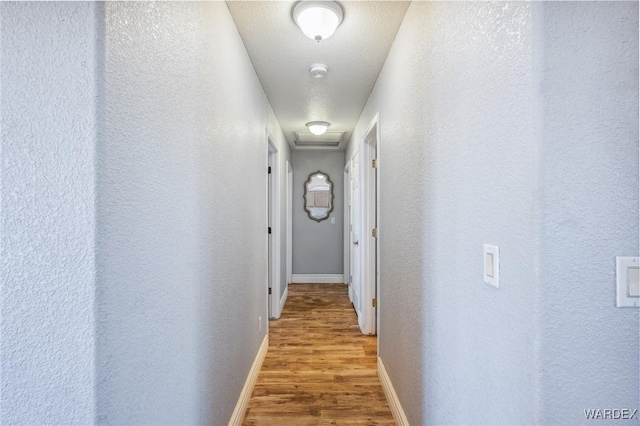 4403 S Via Rialto Ln, Fort Mohave, AZ 86426 - corridor featuring baseboards, a textured wall, attic access, and wood finished floors