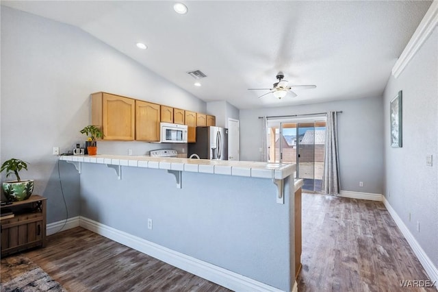 4403 S Via Rialto Ln, Fort Mohave, AZ 86426 - kitchen with stainless steel refrigerator with ice dispenser, visible vents, white microwave, tile counters, and a breakfast bar