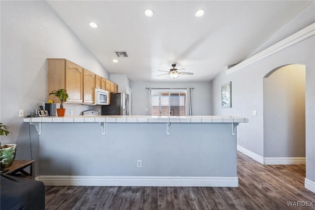 4403 S Via Rialto Ln, Fort Mohave, AZ 86426 - kitchen with freestanding refrigerator, tile countertops, vaulted ceiling, and white microwave