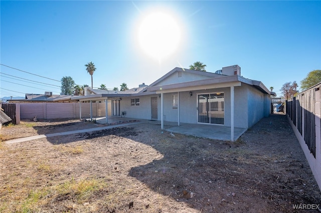 back of house with a patio area, a fenced backyard, and stucco siding