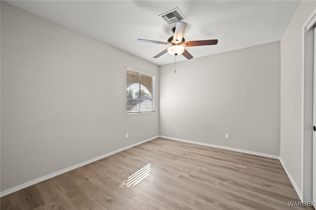 spare room with light wood-style floors, visible vents, baseboards, and a ceiling fan