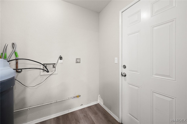 laundry area with dark wood-type flooring, washer hookup, and baseboards