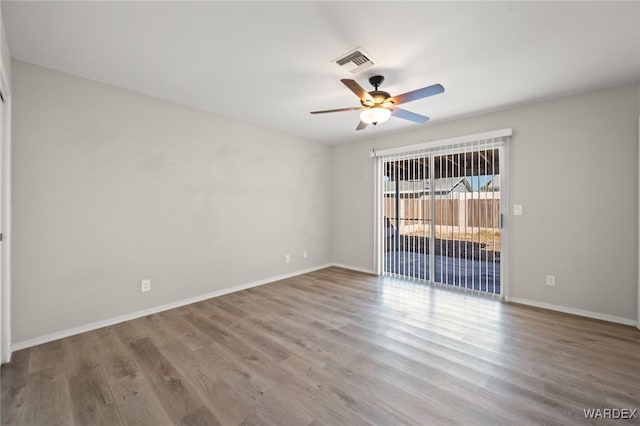 unfurnished room featuring visible vents, ceiling fan, baseboards, and wood finished floors