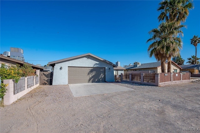 single story home with driveway, a fenced front yard, and stucco siding