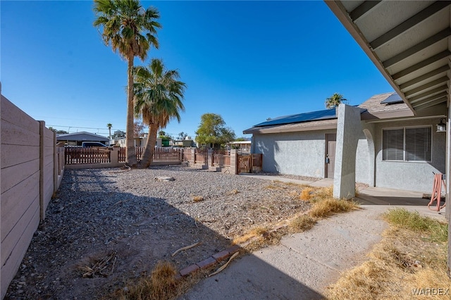 view of yard with a fenced backyard and a gate