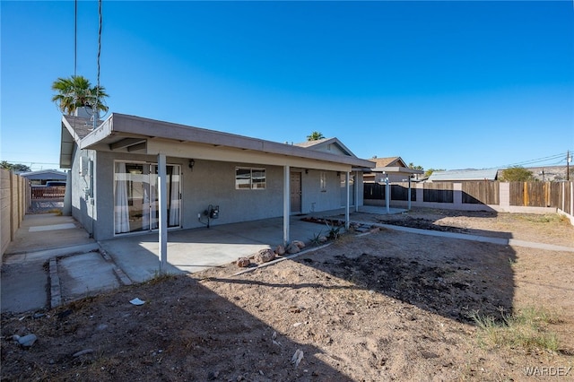 back of property with a patio, a fenced backyard, and stucco siding