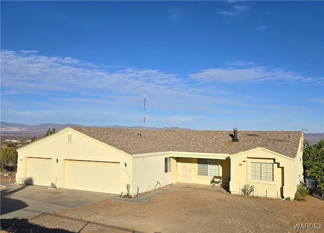 single story home with stucco siding, driveway, central AC, and a garage