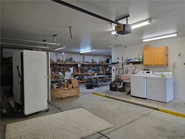 garage with a workshop area, a garage door opener, independent washer and dryer, and freestanding refrigerator