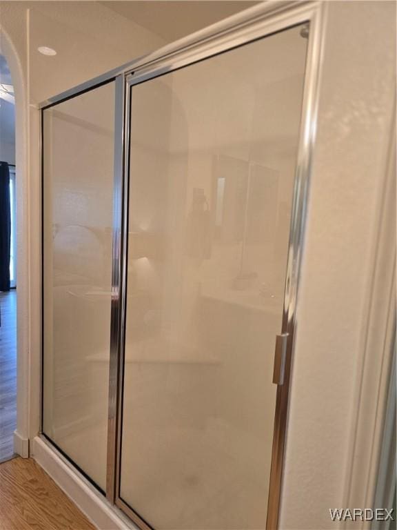 full bathroom with a shower stall and wood finished floors