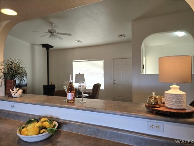 kitchen with recessed lighting, visible vents, a ceiling fan, and a wood stove