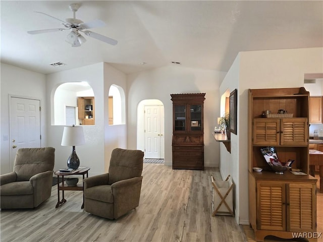 sitting room featuring visible vents, ceiling fan, light wood-style floors, and vaulted ceiling