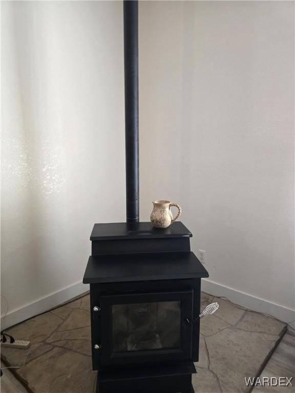 interior details with baseboards and a wood stove