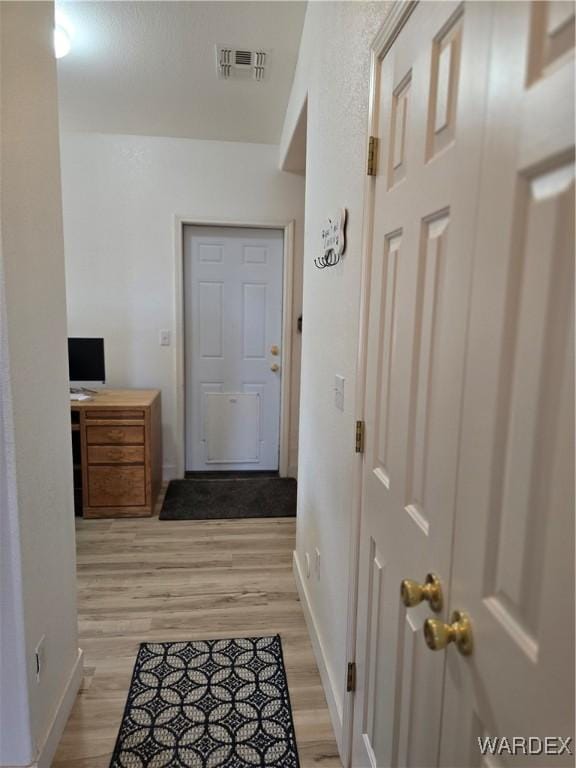 entryway featuring light wood-type flooring, baseboards, and visible vents