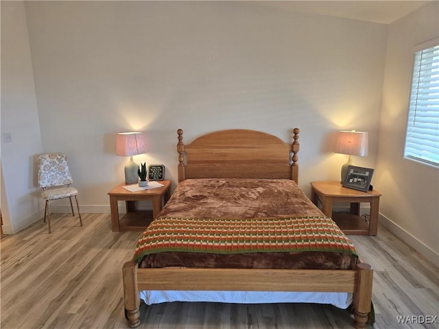 bedroom featuring baseboards and wood finished floors