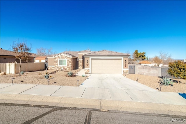 view of front facade featuring driveway, a garage, fence, and stucco siding