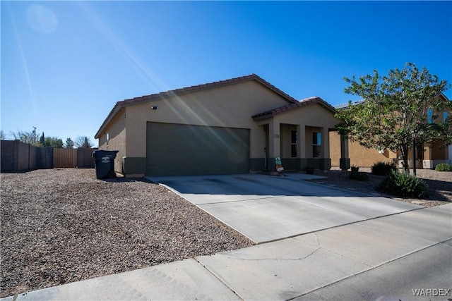 view of front of house featuring a garage, a tiled roof, concrete driveway, and stucco siding