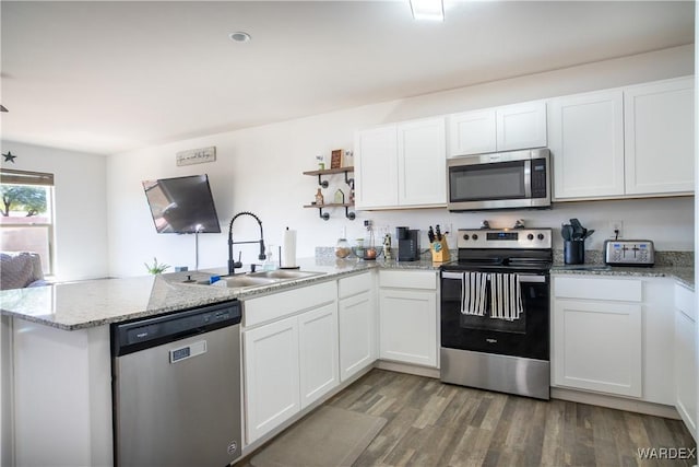 kitchen featuring stainless steel appliances, white cabinetry, a peninsula, and open shelves