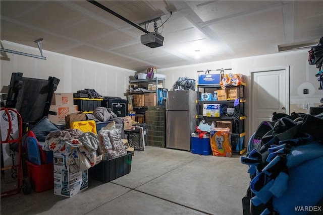 garage featuring a garage door opener and freestanding refrigerator