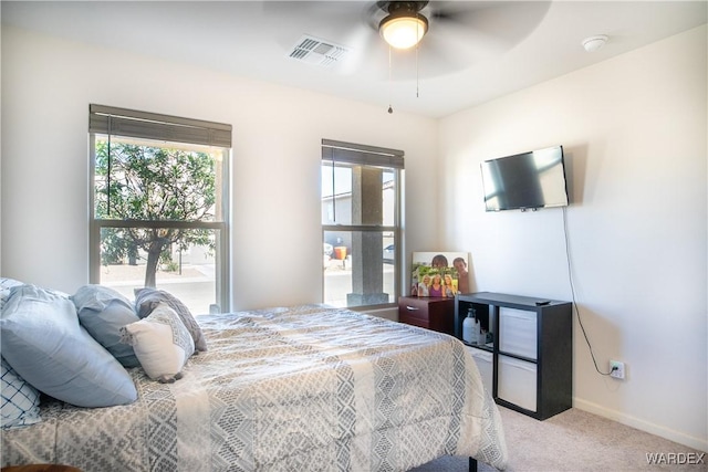 bedroom featuring baseboards, a ceiling fan, visible vents, and light colored carpet